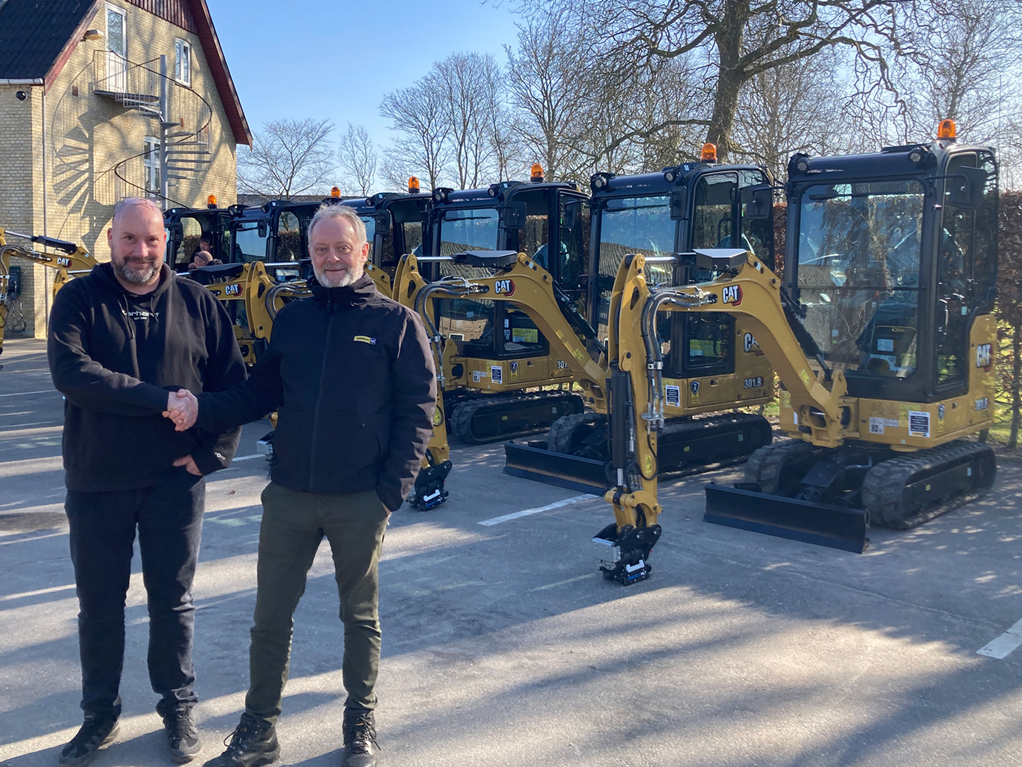 Jens Karstensen og Niels Hansen giver hånd på Cat 301.8 minigravemaskiner